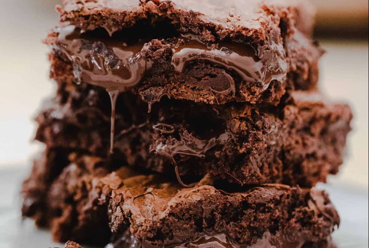 Three brownies stacked, oozing with melty chocolate.