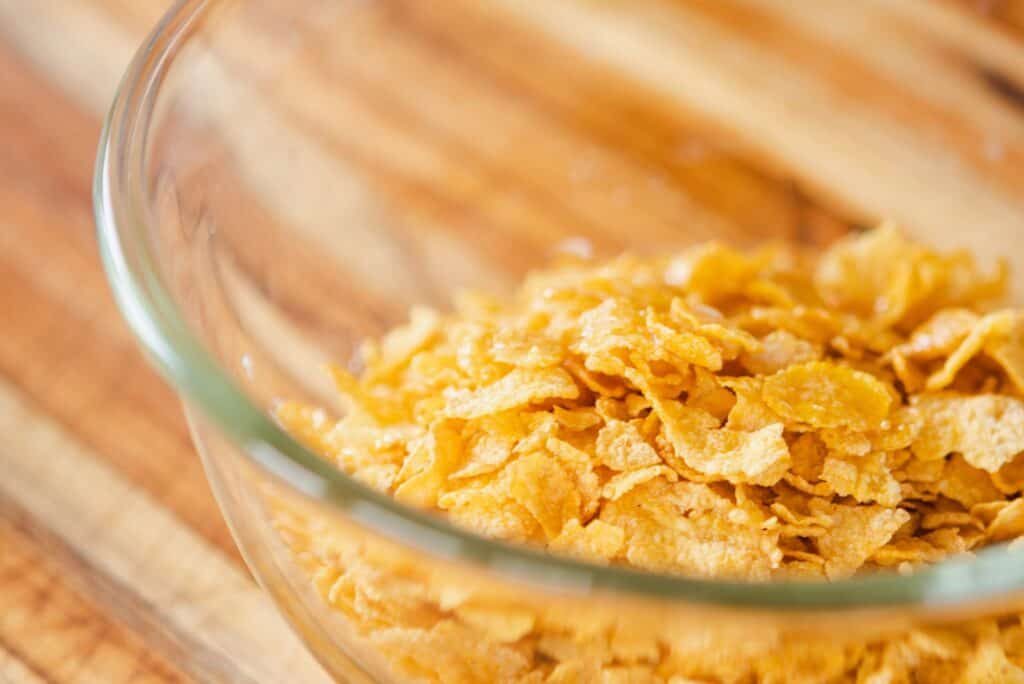 Cornflakes sit in a glass bowl.