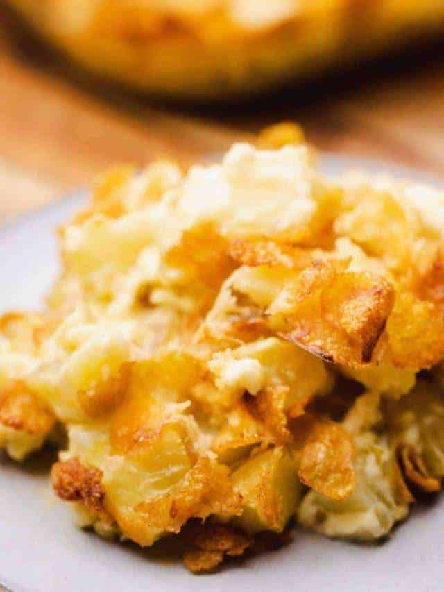 Plate of cooked Funeral Potatoes sits ready to be enjoyed.