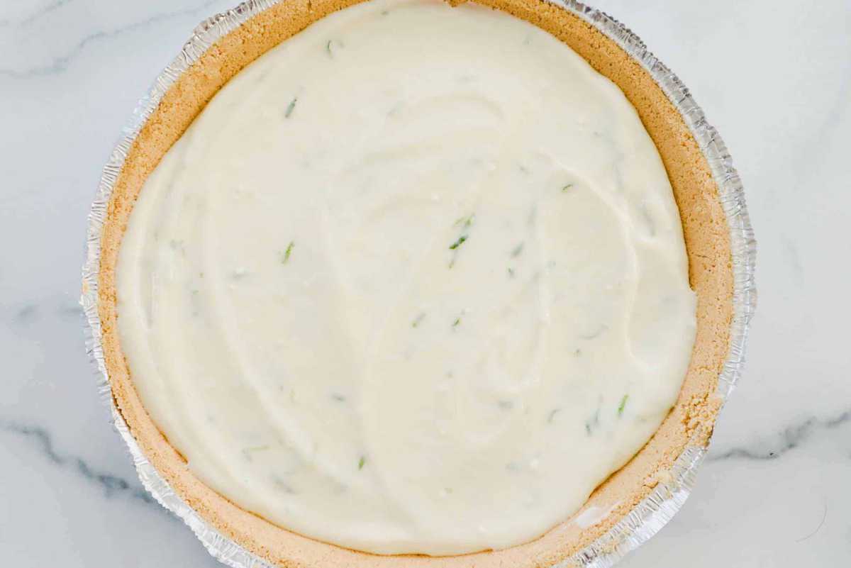 Key lime pie filling has been added to the pie crust.