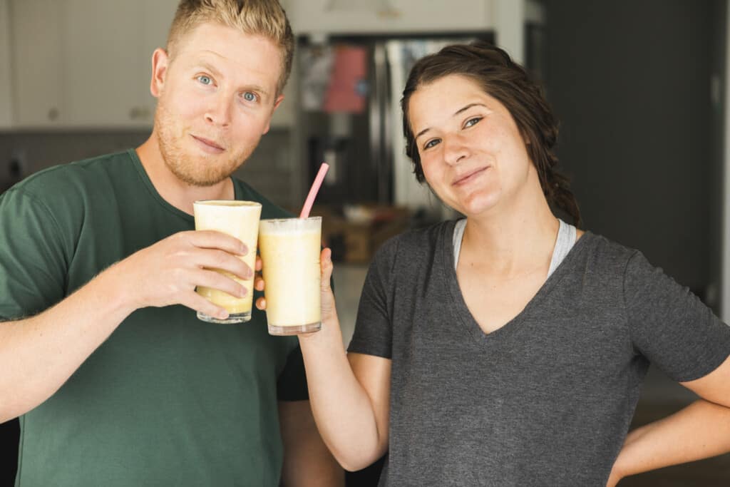 Two people happily drinking an orange julius (serve immediately)