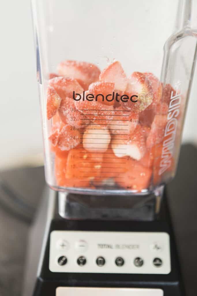Blendtec blender is full of watermelon and frozen strawberry chunks, waiting to be blended.