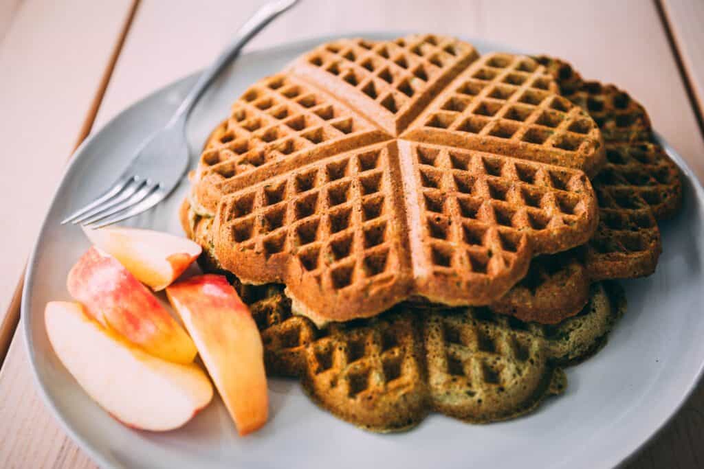 Stack of Healthy Green Smoothie Waffles sit on a plate ready to eat and enjoy.