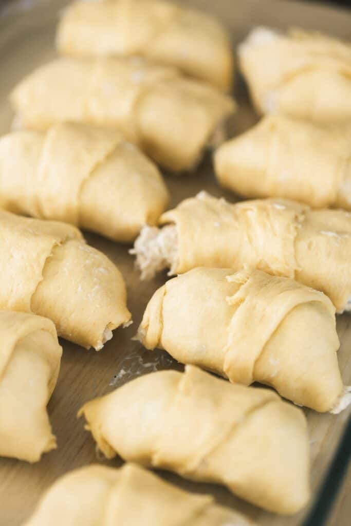 Crescents have been filled and rolled then placed on a baking sheet.