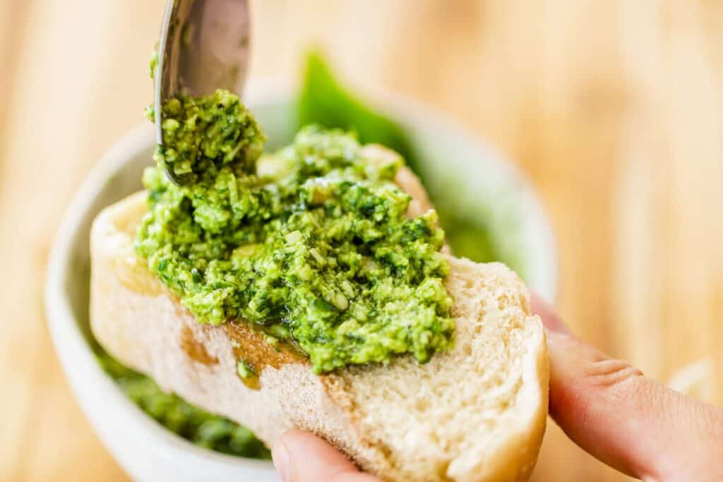 Fresh homemade pesto is spread over a baguette for a tasty Super Bowl food option.