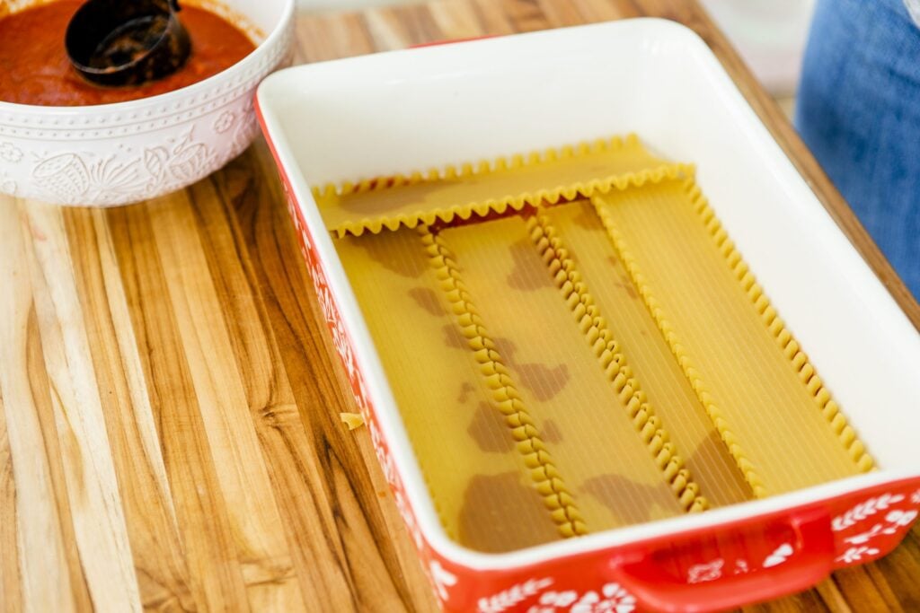 Noodles line the bottom of a casserole dish ready to build your lasagna.