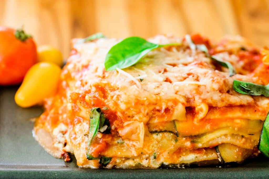 Slice of lasagna sits on a plate ready to eat.