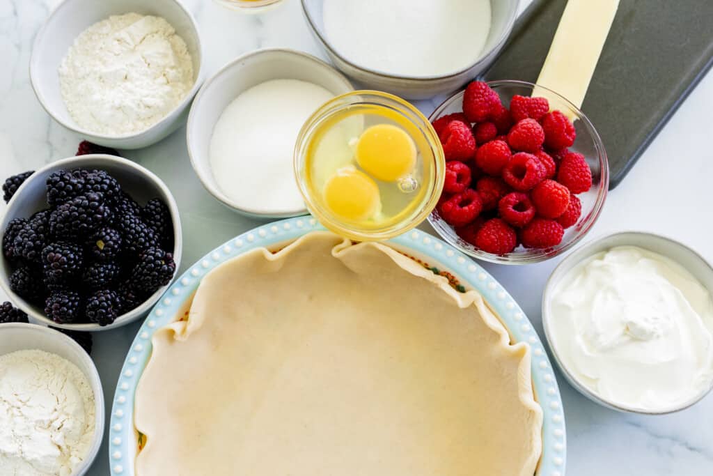 All the ingredients for double berry custard pie sit on the counter ready to combine.
