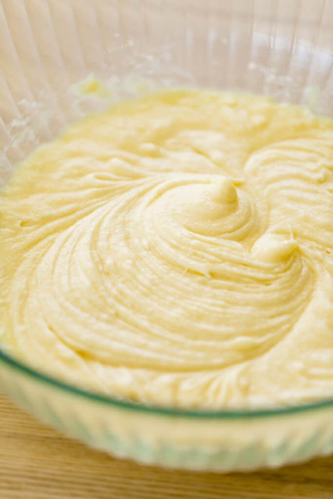 Cake batter sits in a large glass bowl.