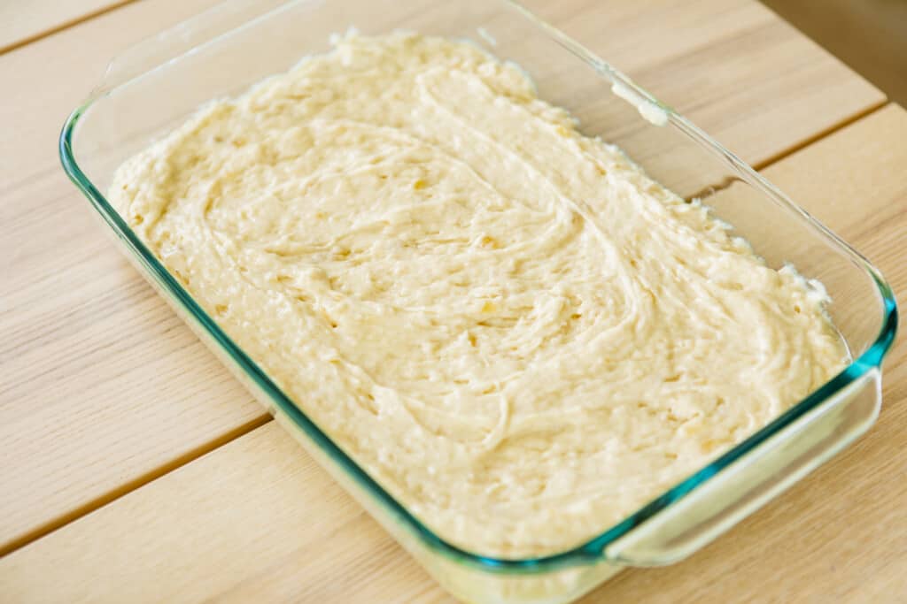 Fluffy, ivory colored batter sits in a glass baking dish.