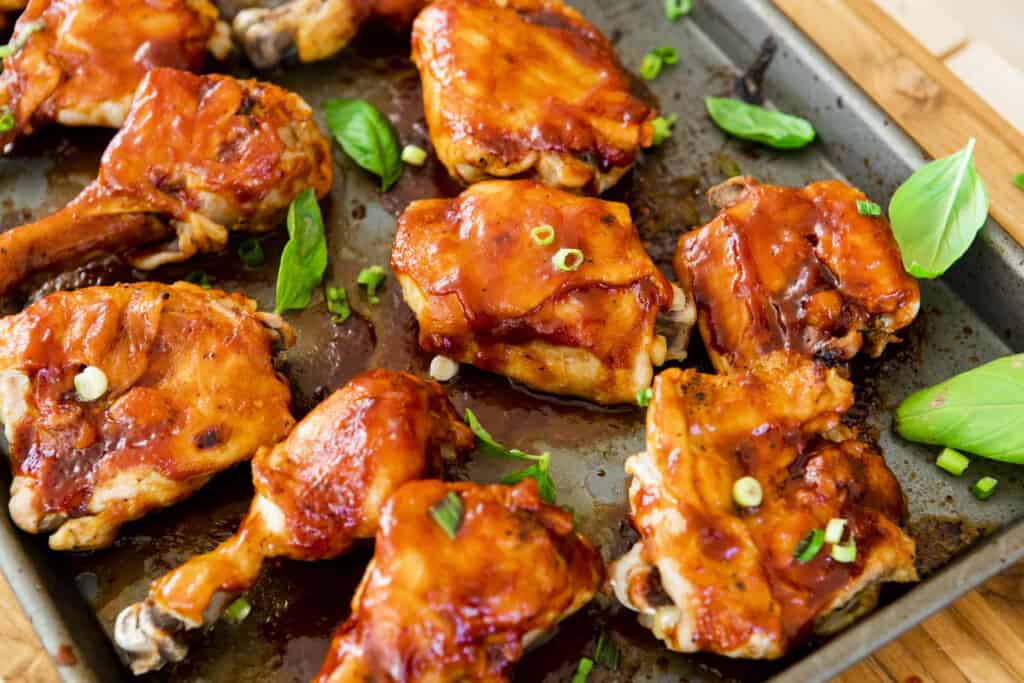 9 pieces of cooked chicken sit on a pan, dressed and ready to enjoy. The skin is crispy, sauce caramelized and meat tender.