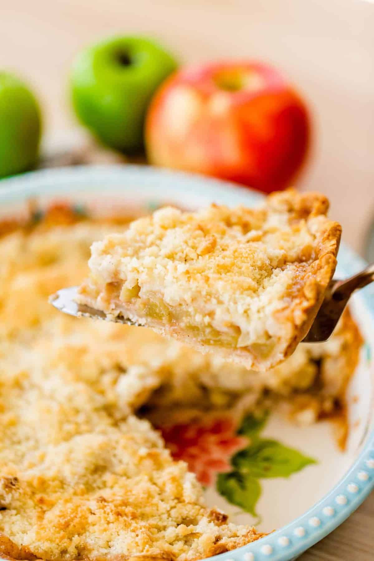 A slice of Dutch Apple pie sits on a pie serving spatula ready to move to a plate.
