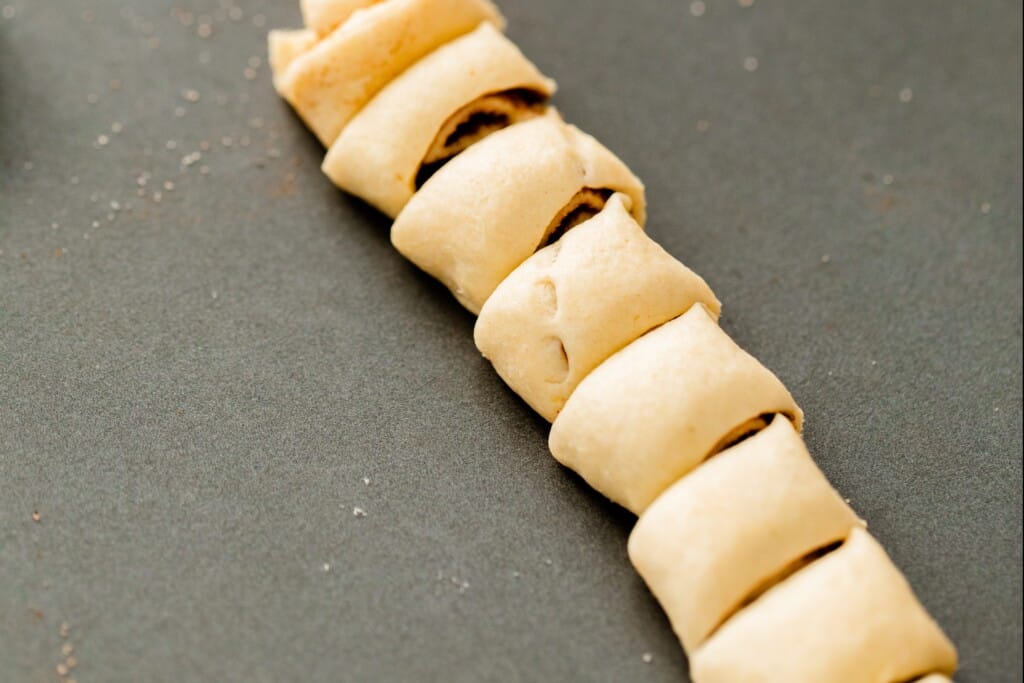 Crescent dough has been rolled lengthwise and cut in to one inch sections resembling mini cinnamon rolls.