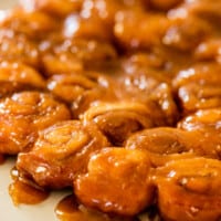 Ooey-gooey caramel rolls sit on a serving plate ready to be eaten and enjoyed on Christmas morning.