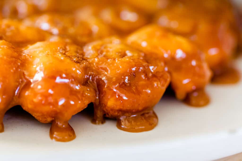 Ooey-gooey caramel rolls sit on a serving plate ready to be eaten and enjoyed on Christmas morning.