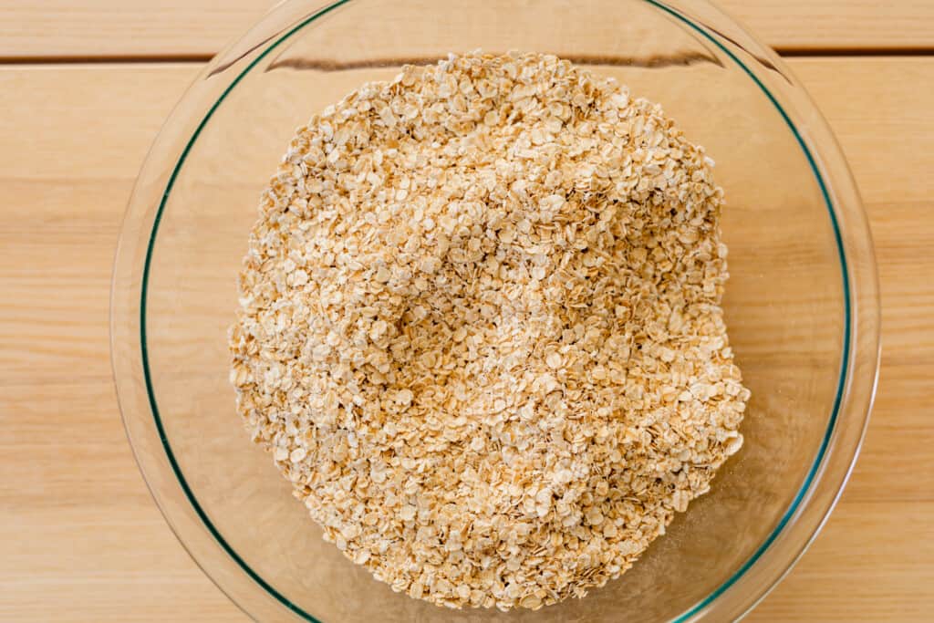 Glass bowl is filled with rolled oats.