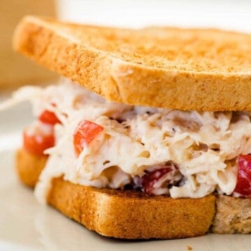 Chicken salad on toasted whole wheat bread is served on a plate.
