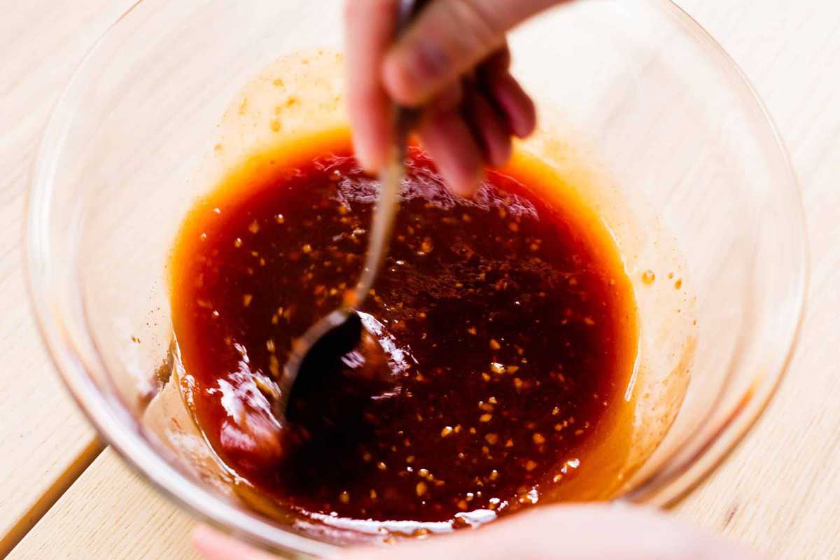 Honey garlic sauce is being stirred in a bowl.