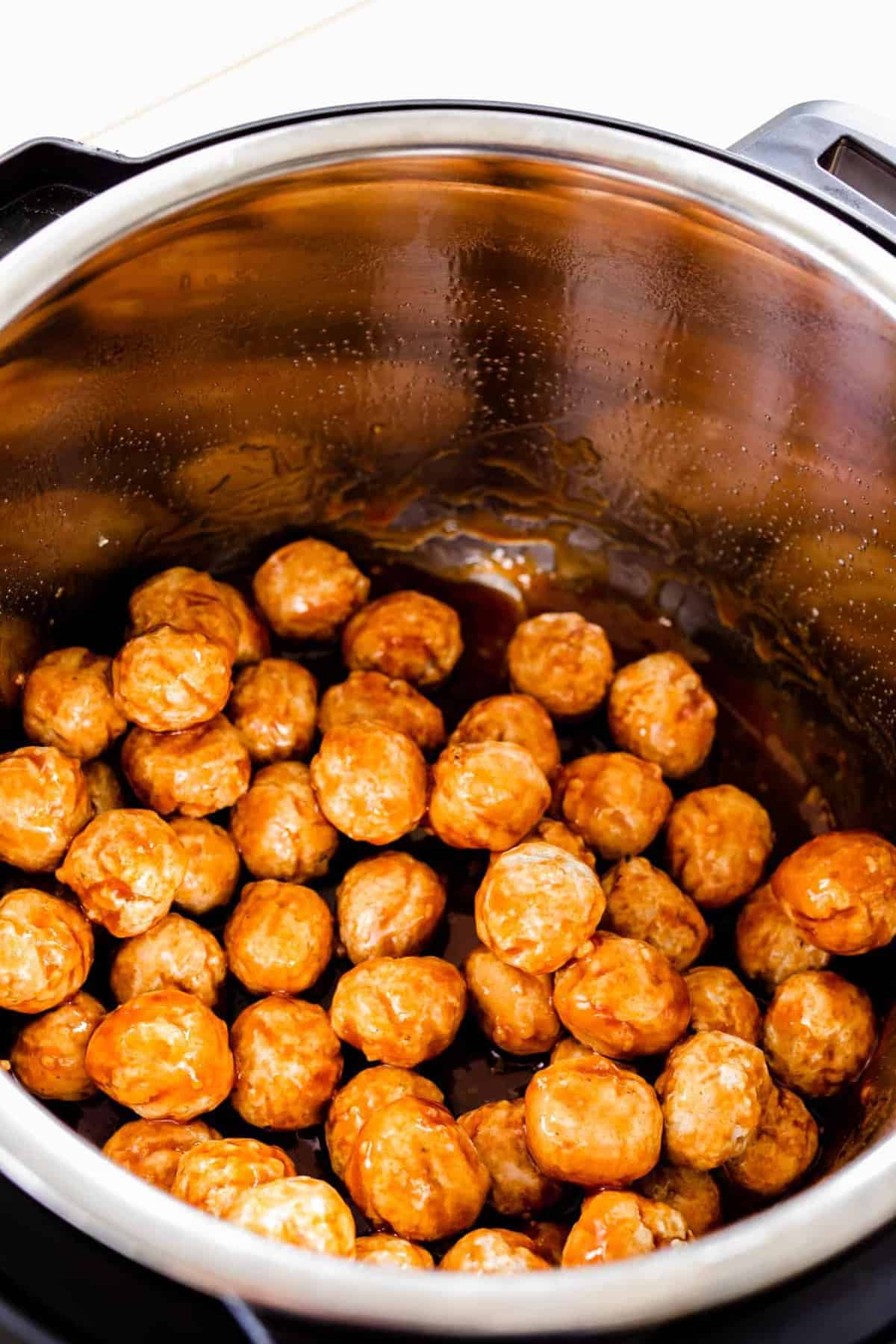 Meatballs are stirred in sauce to make sure they are covered.