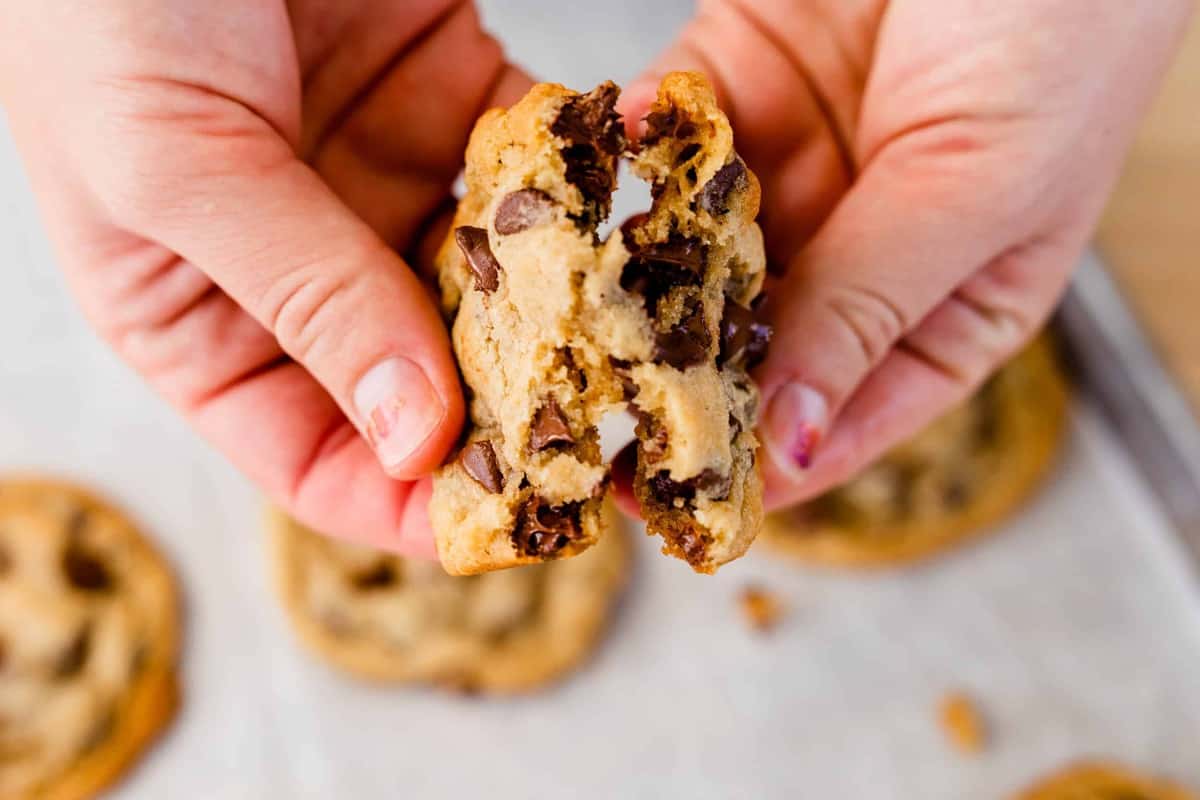 Ashley breaks a fresh chocolate chip cookie in half to see all the gooey chocolate inside.