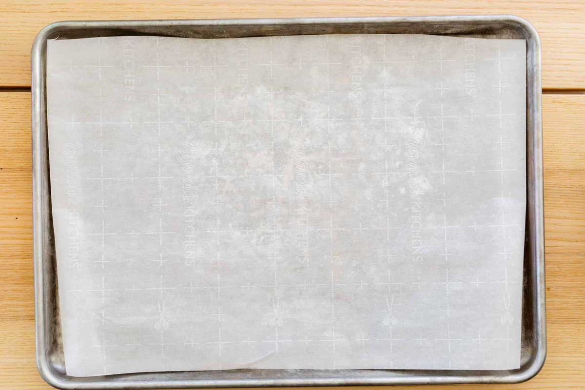 A baking sheet is lined with a piece of fresh parchment paper.