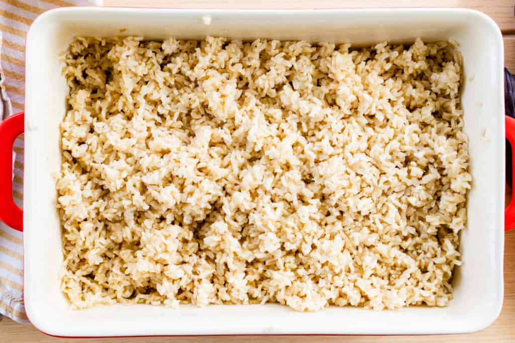 Ceramic casserole dish sits on table top full of perfectly fluffy brown rice.