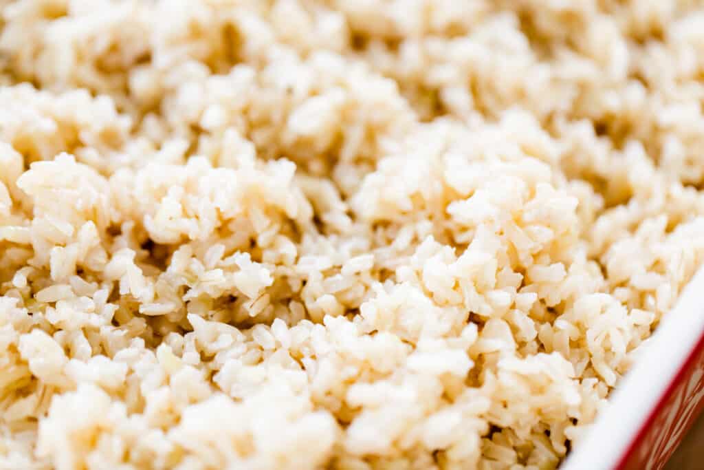 Fluffy baked brown rice sits in a ceramic casserole dish ready to serve.