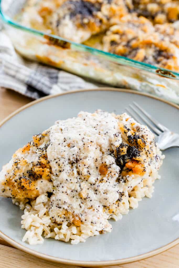 Rice sits on a plate, topped with poppy seed chicken casserole.