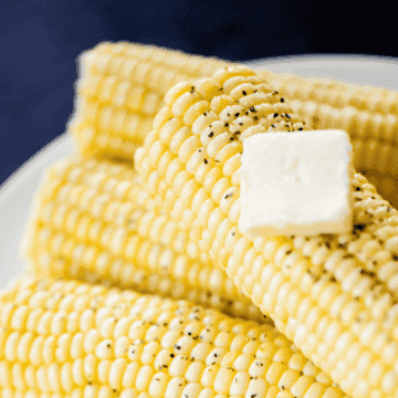 A stack of corn sits on a plate ready to eat and enjoy.