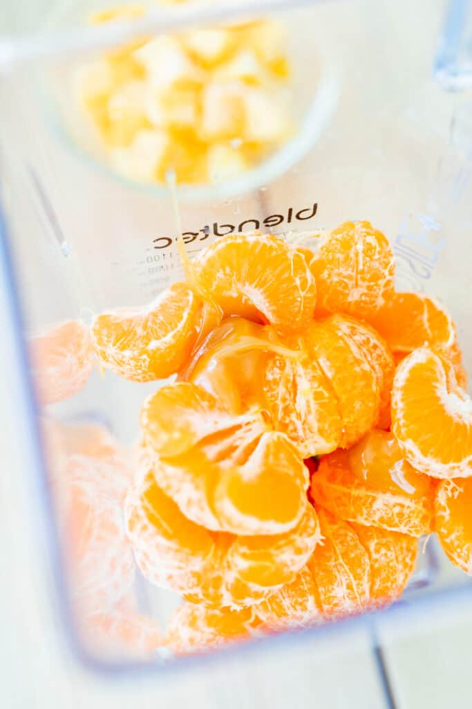 Open blender full of clementine oranges.