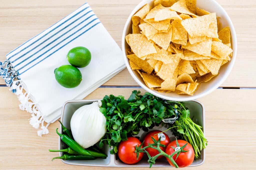 The ingredients for Pico de Gallo sit out on a countertop, ready to be chopped and combined.