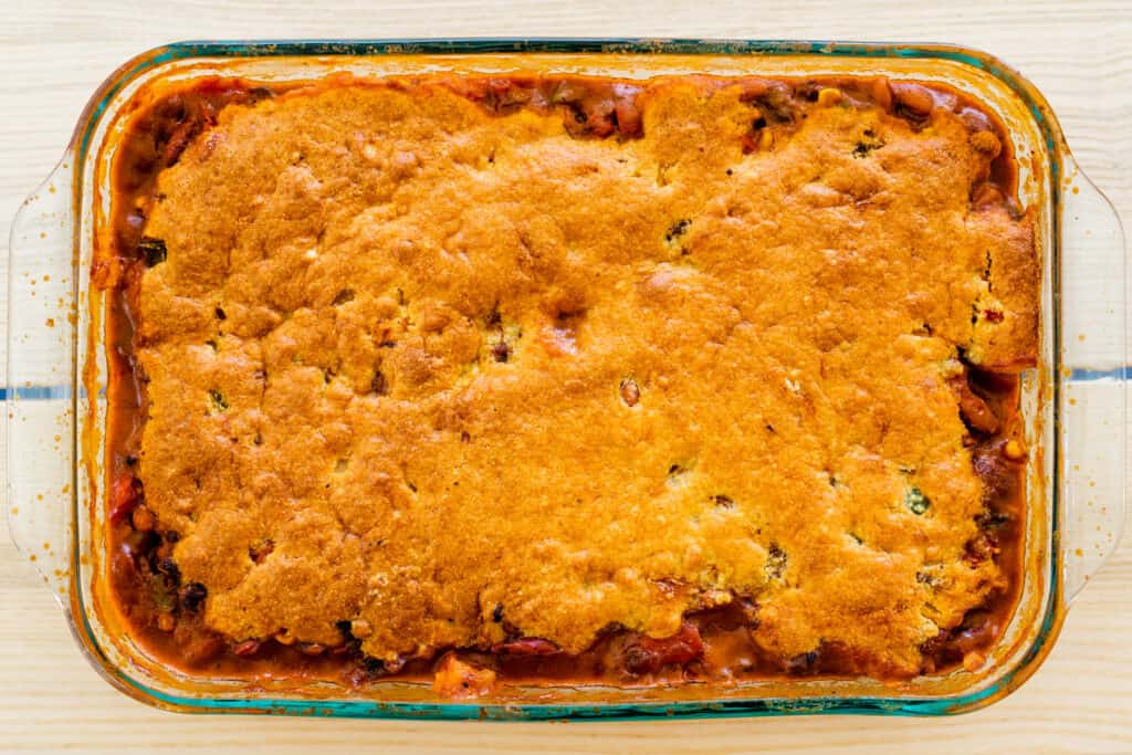 Baked casserole dish of southwestern tamale pie sits on countertop.