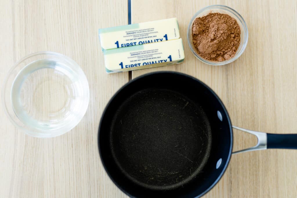 Water, butter and cocoa powder sit beside a pot ready to be heated and then added to the cake mixture.