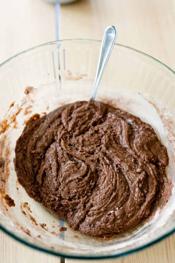 In a glass bowl cake mix, butter and evaporated milk are combined to make a thick brownie batter.