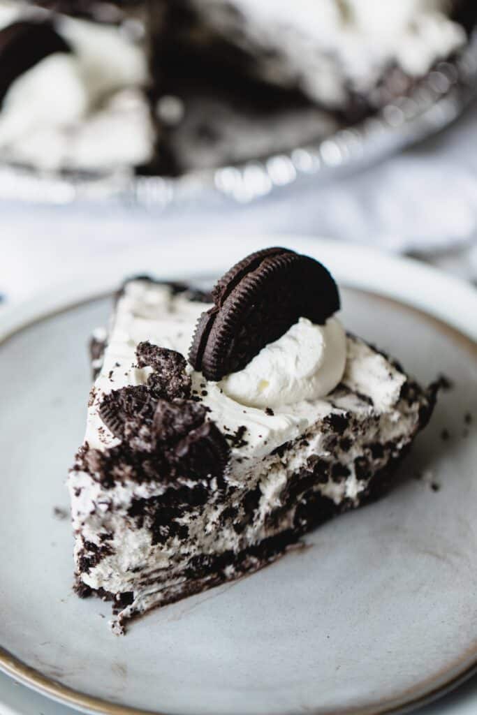 A slice of Oreo cream pie sits on a plate ready to enjoy.