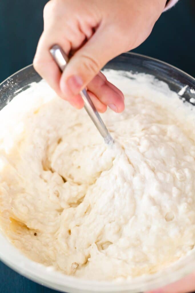 Batter for waffles rests in a glass bowl.