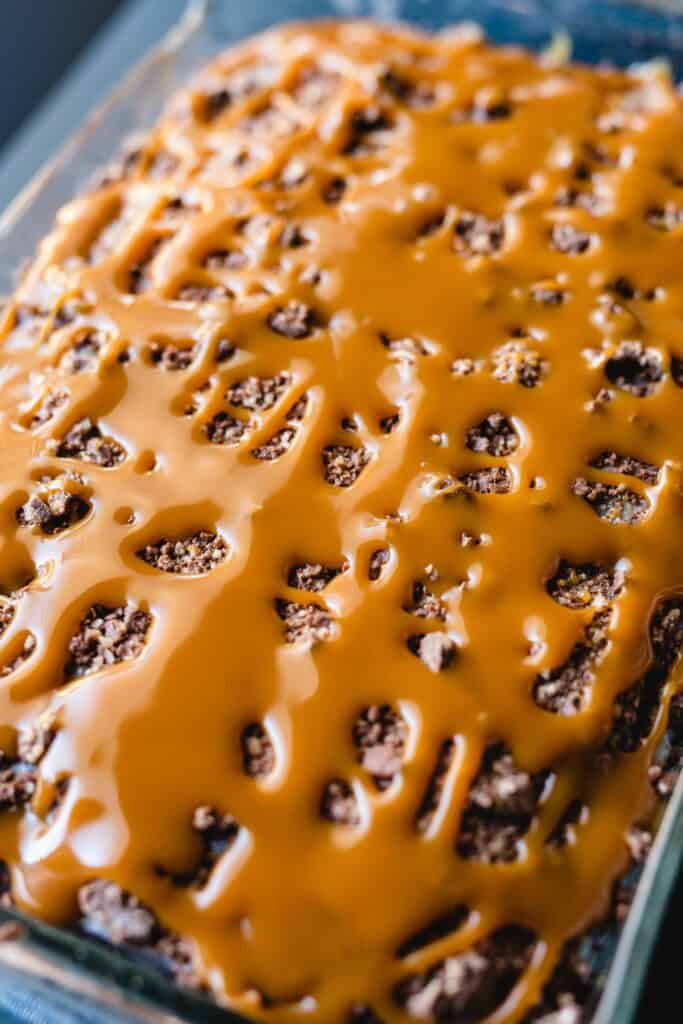 Caramel sauce covers the top of a chocolate cake.