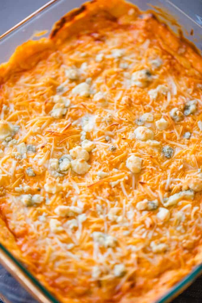 A dish of buffalo chicken dip is baked till golden and bubbly, ready to serve.