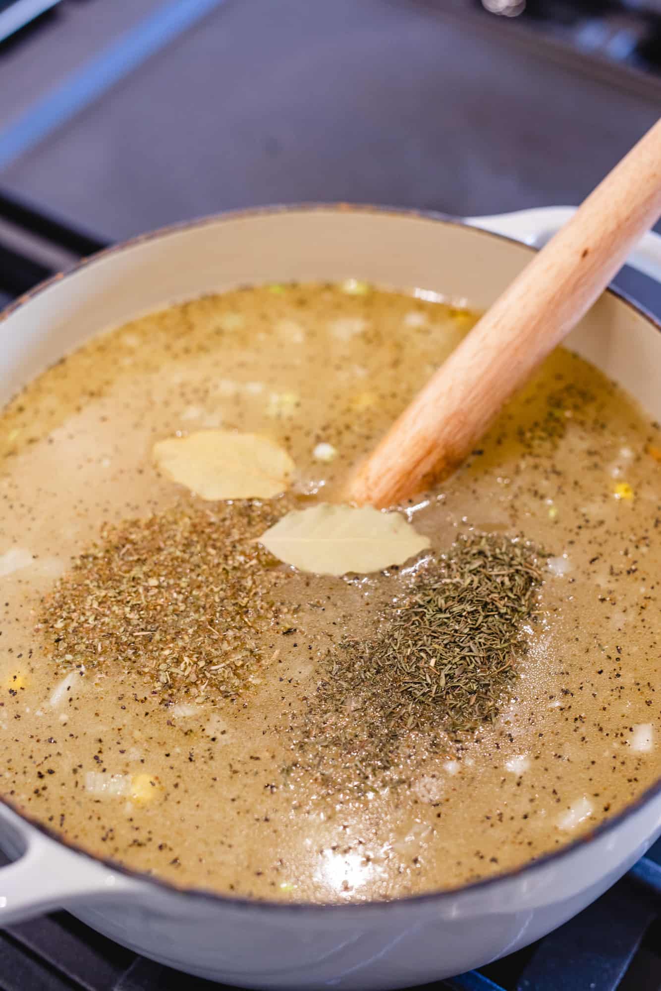 Broth and seasonings for Chicken Noodle soup sit in a pot to be mixed.