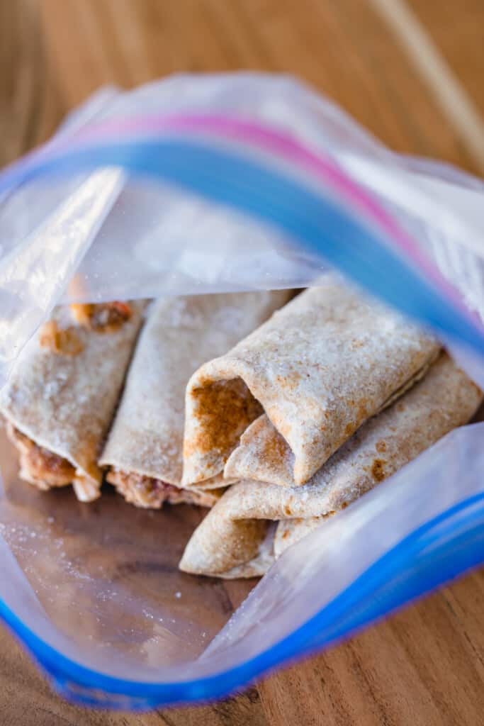 Frozen beef freezer burritos sit in a storage bag ready to reheat.