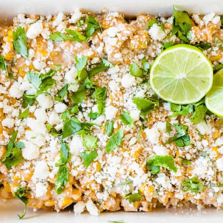 Mexican Street Corn Elote Salad is topped with fresh limes and cilantro.