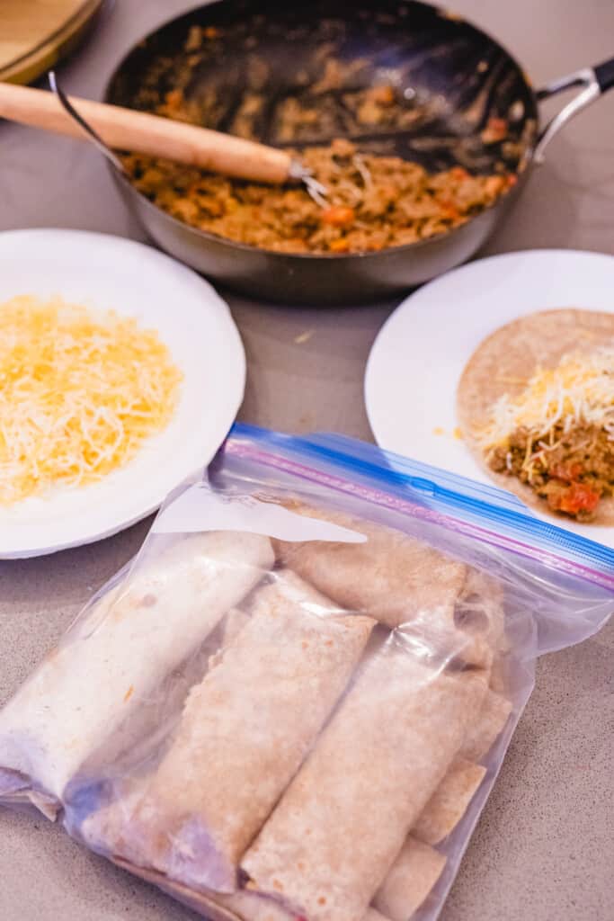 Bag of prepared freezer burritos sits next to plate with burrito on it to eat.
