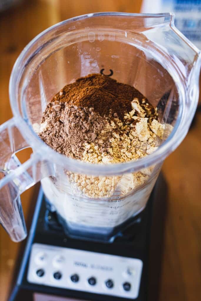 A blender full of ingredients for a peanut butter protein shake.