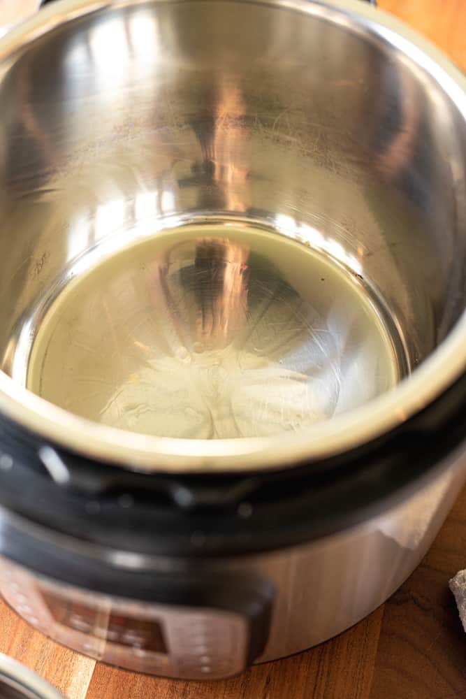 Oil sits in the bottom of a heated instant pot for searing.