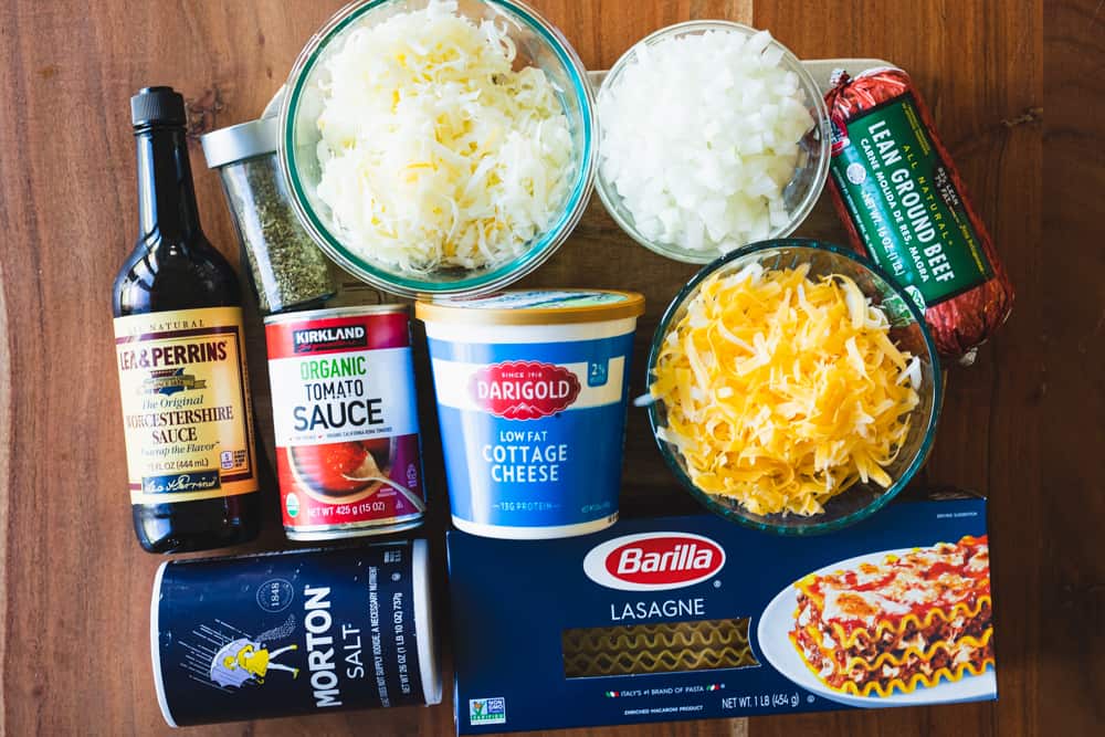 All ingredients for easy lasagna with cottage cheese sit on a wooden counter ready for assembling.