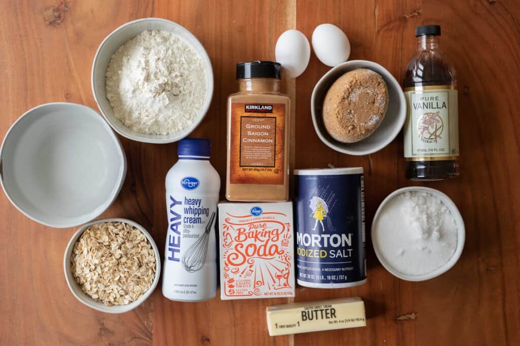 Ingredients for oatmeal cake lay out on a wooden counter waiting to be combined.