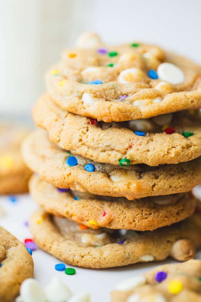 Five soft and chewy golden brown cookies sit stacked ready for eating.