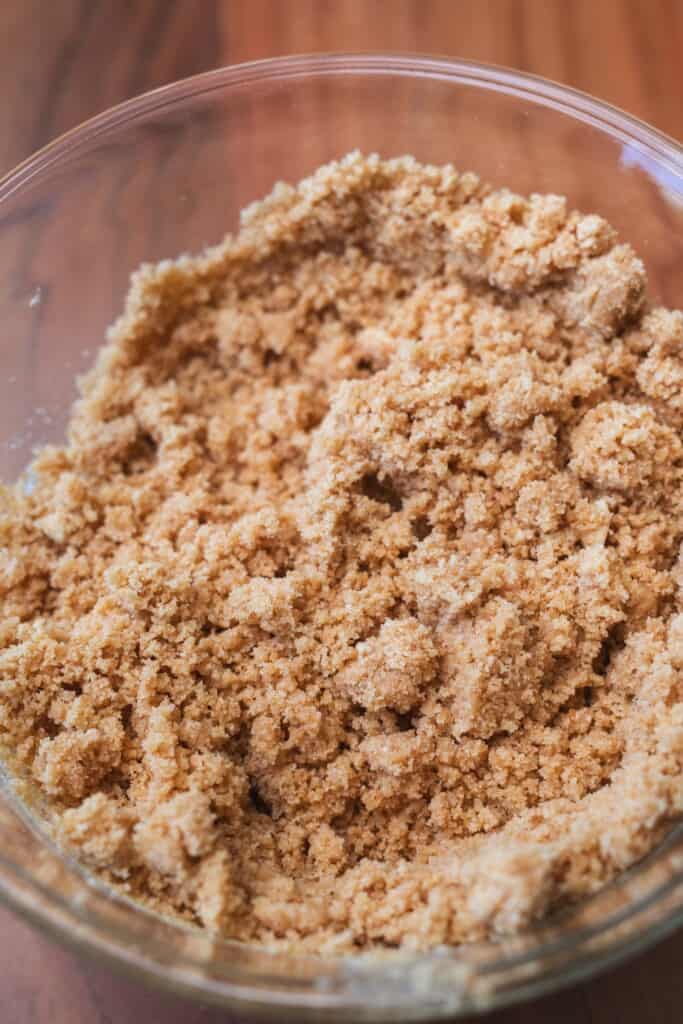 Sandy cookie crumble mixture sits in a glass bowl.