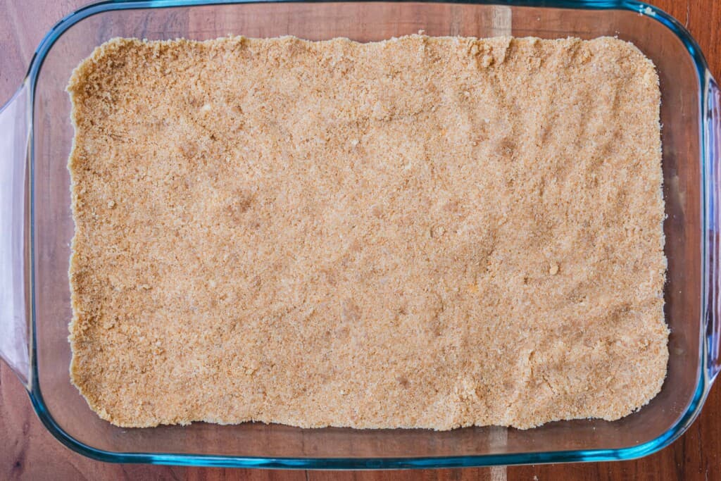 Cookie crumbs are pressed into a glass 9"x13" dish to form a crust.