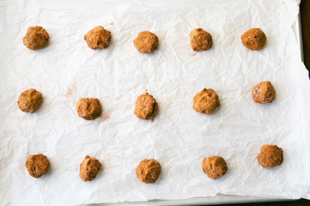 Cookie dough sits on a lined baking sheet.